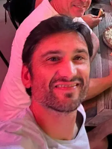Alex, le coach, souriant à table après un match